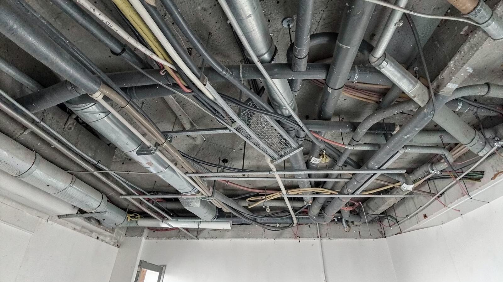 Jalur ducting, tray kabel, dan perpipaan di atas plafon.